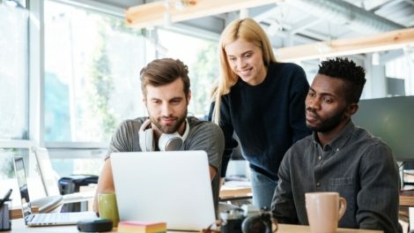 happy-colleagues-sitting-in-office-coworking-PHYA6TG-470x318