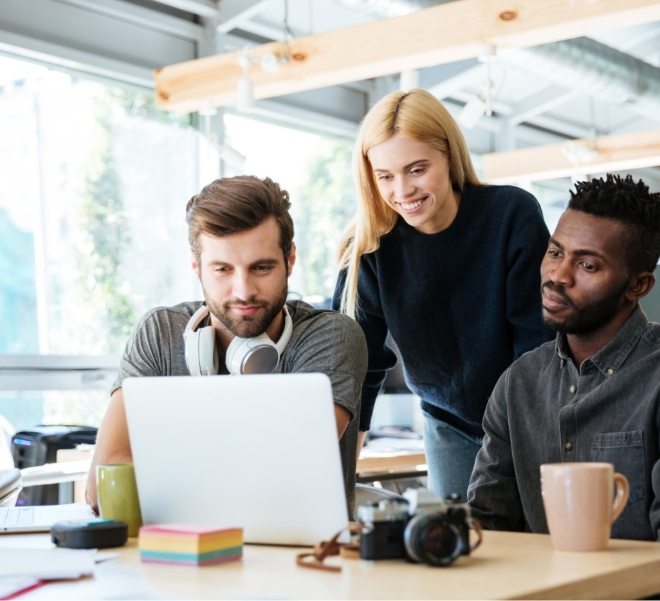 happy-colleagues-sitting-in-office-coworking-PHYA6TG-1