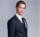 demo-attachment-1114-handsome-young-businessman-standing-against-gray-PFGZN4E