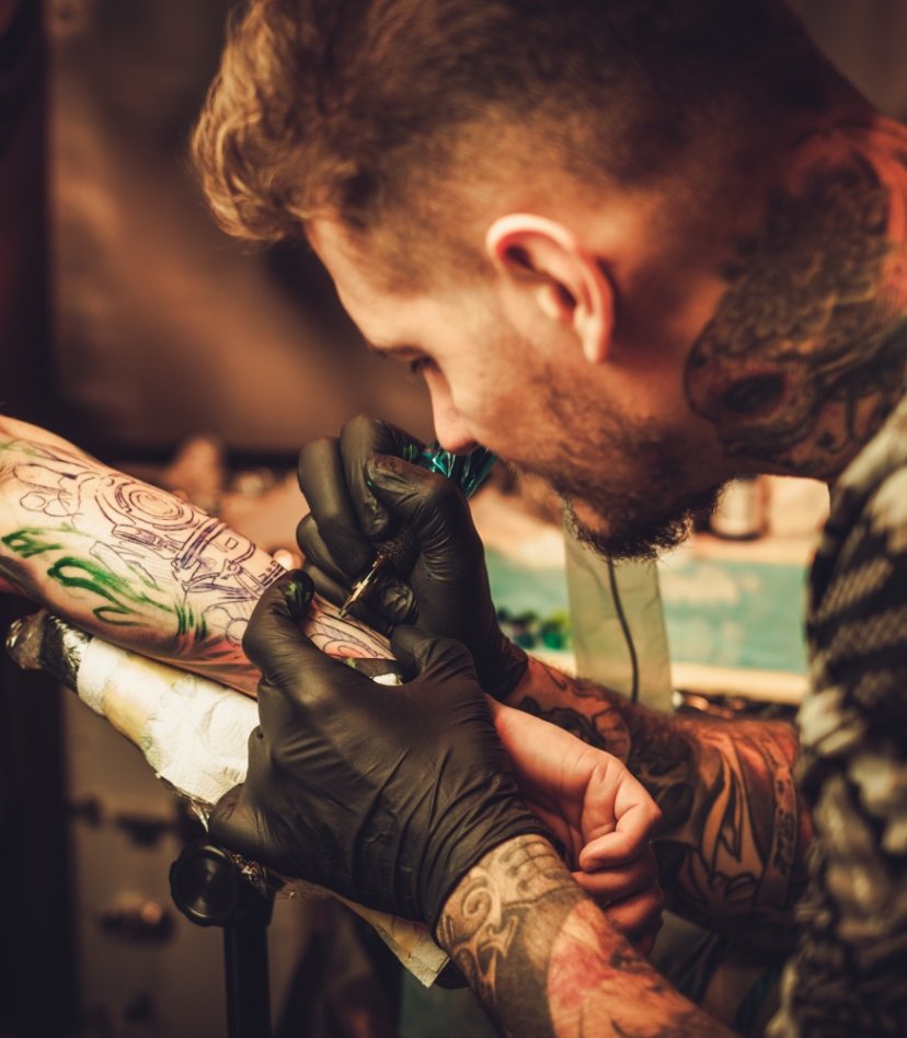 tattoo-artist-makes-a-tattoo-on-a-mans-hand-PECZRE2